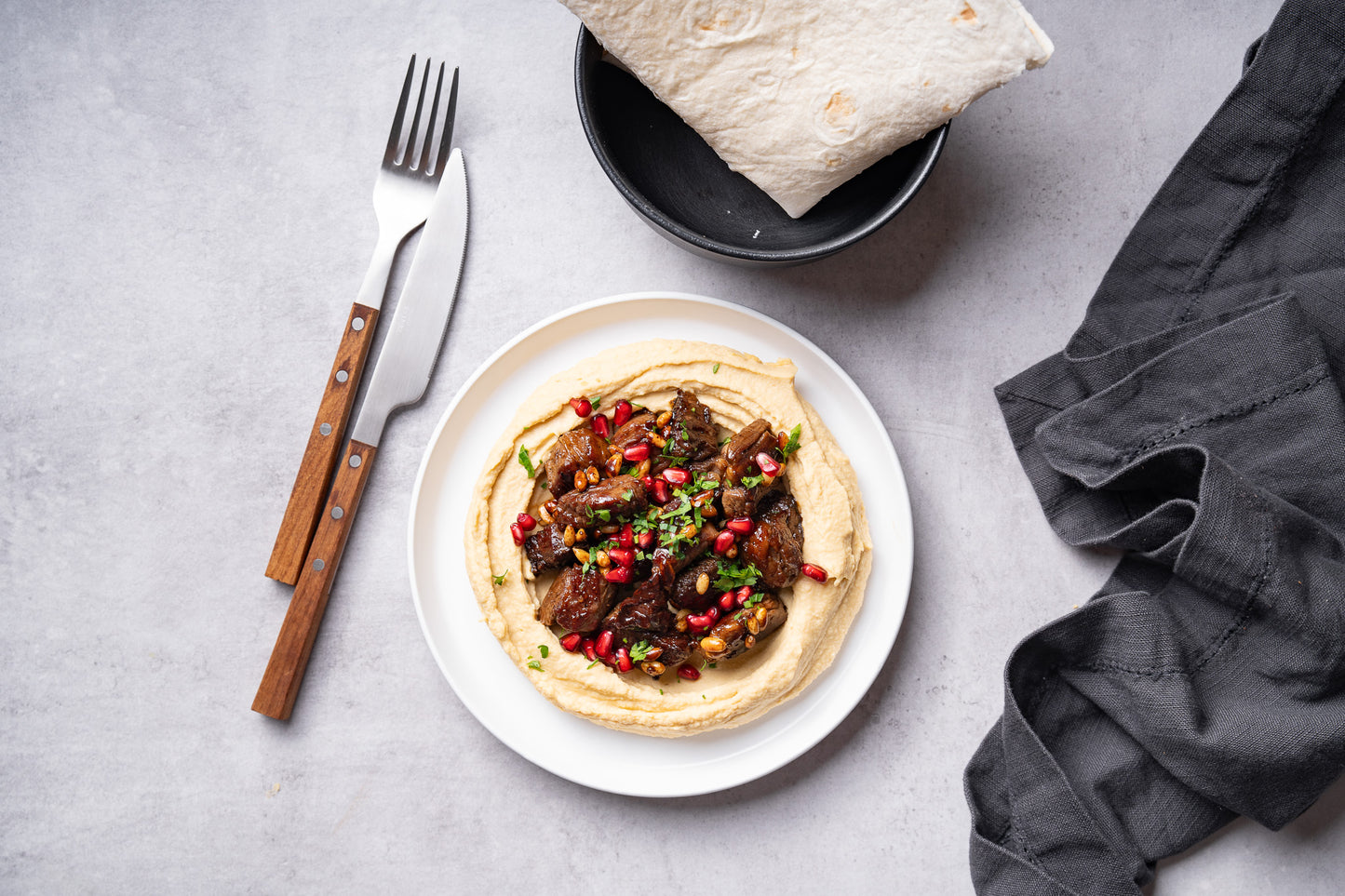 Vită cu hummus, semințe de pin și reducție de rodie
