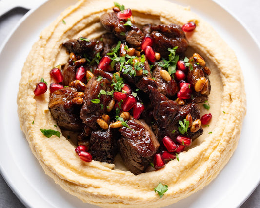 Vită cu hummus, semințe de pin și reducție de rodie