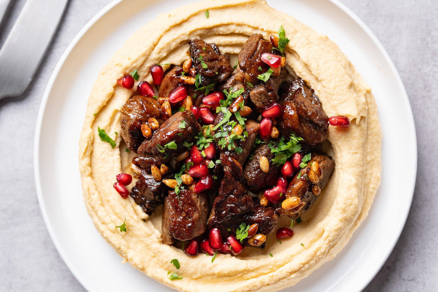 Vită cu hummus, semințe de pin și reducție de rodie