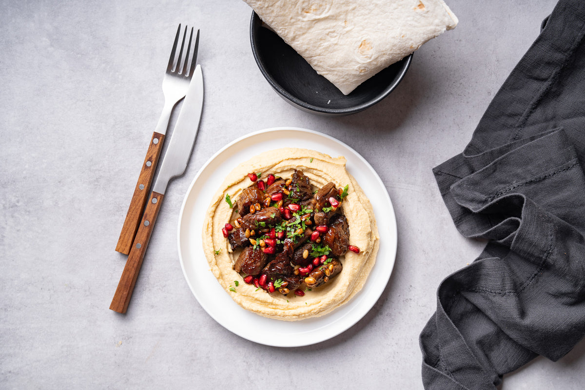 Vită cu hummus, semințe de pin și reducție de rodie